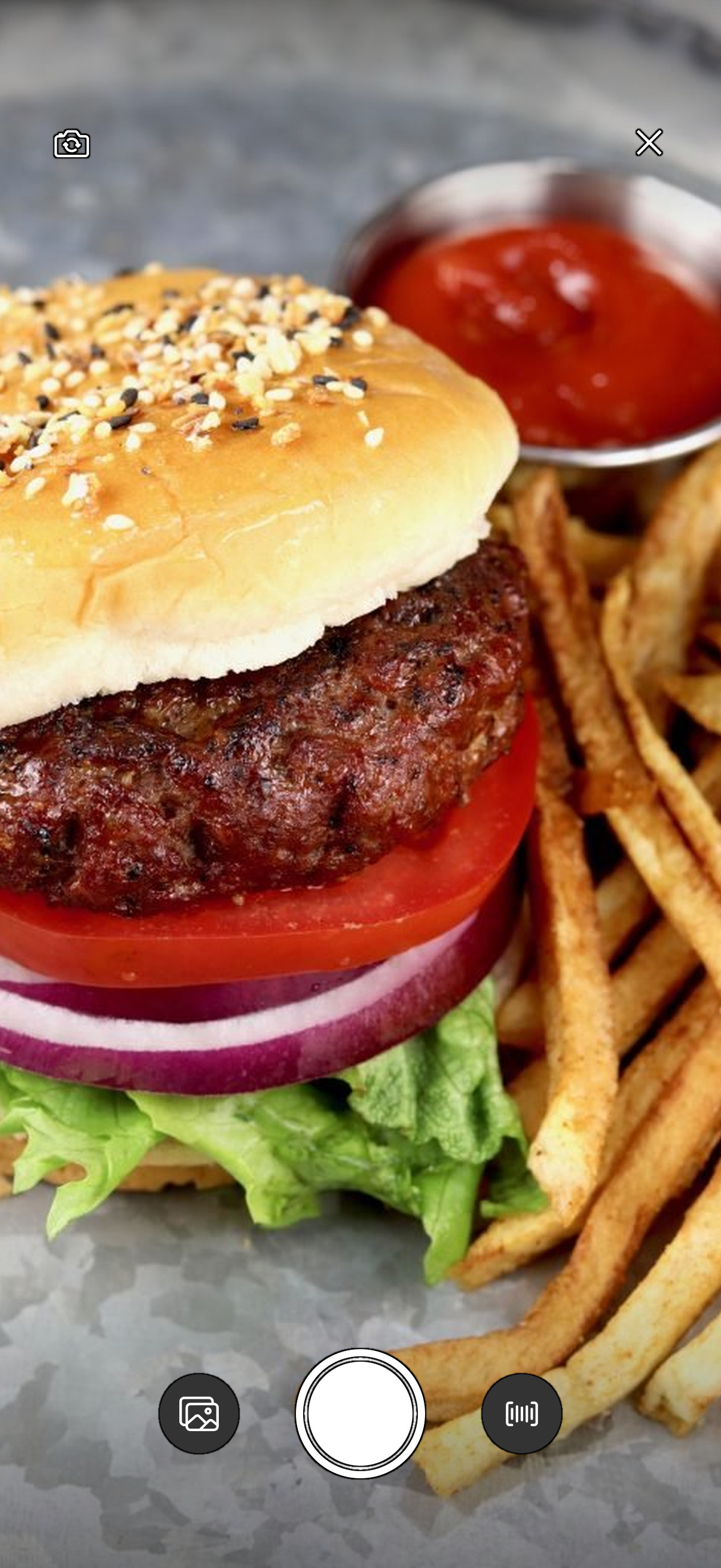 Snapping a photo of a burger to log it: the camera framed on the meal so Fitly can identify it and log the full macro breakdown